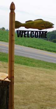 Fish on Cedar Post with black metal welcome sign