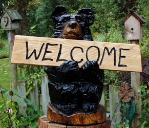 Black Bear holding a Welcome sign